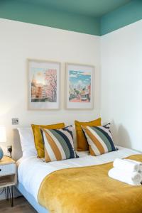 a bedroom with a large white bed with pillows at Large 4BR Contractor-Friendly House - Sleeps 10 - Free parking - North London in Enfield