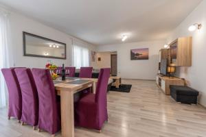 a dining room with a table and purple chairs at Holiday home Galižana in Galižana +30 photos