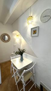 a white table and chairs in a room with a clock at Harmonia De La Mar in Altea