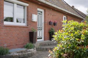 a brick house with a white door and windows at 3 Raum Ferienwohnung Im 1 Og in Cuxhaven