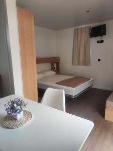 a small room with a bed and a table and chairs at Camping Relax Sol in Torredembarra