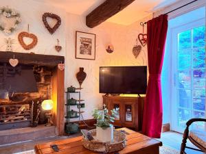 un soggiorno con tv e camino di The Buttoned Hearth in Ullswater a Penrith