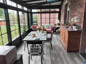 a kitchen with a table and chairs and windows at LA CHARMERAIE in Arrest