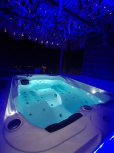 een jacuzzi in een kamer met blauwe verlichting bij Anglada, Villa with a private pool and jacuzzi in Lloret de Mar