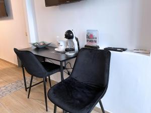 a black table with two chairs and a phone on it at Annarè House in Ischia