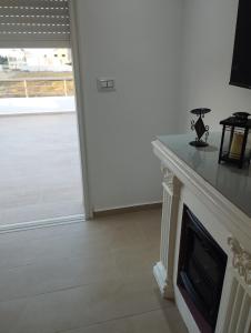 een woonkamer met een open haard en een glazen schuifdeur bij kelibia ezzahra plage a pied in Kelibia +8 foto's