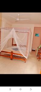 un dormitorio con una cama con mosquitera en Dilena Beach Inn, en Tangalle