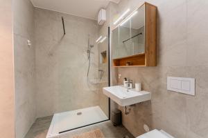 a white bathroom with a sink and a shower at Flex SelfCheckIns 142 - Zagreb - Bedroom - Garage - Loggia in Zagreb