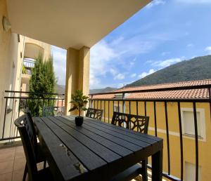 a wooden table on a balcony with a view of a mountain at Les Naïades G32 - 2 chambres pour 5 personnes ! in Avène