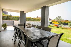 a dining room table with chairs and a bottle of wine at Holiday home Galižana in Galižana