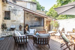 un patio extérieur avec des chaises et un parasol dans l'établissement Gîte de l'Antiquaire au cœur de la Citadelle Blaye, à Blaye