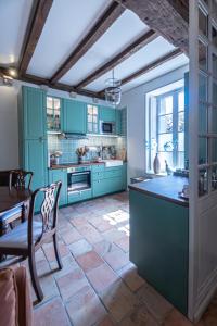 une cuisine avec des armoires bleues et une table et des chaises dans l'établissement Gîte de l'Antiquaire au cœur de la Citadelle Blaye, à Blaye