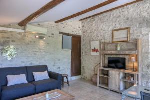 a living room with a couch and a tv at Escapade romantique en Drôme, vue sur les vignes in Solérieux