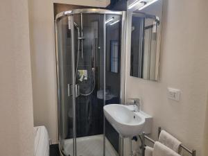 a bathroom with a glass shower and a sink at Victoria's Urban Nest in Brescia