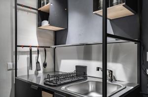 a kitchen with a sink and a stove at Victoria's Urban Nest in Brescia