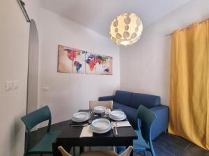 a dining room with a table and a blue couch at Victoria's Urban Nest in Brescia
