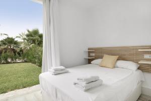 a bedroom with a white bed with towels on it at Sueña La Breña in Barbate +101 photos