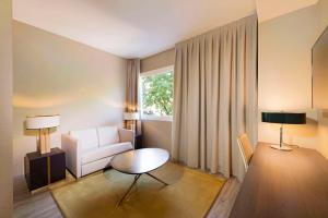 a living room with a couch and a table at NH Collection Madrid Suecia in Madrid