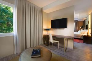 a hotel room with a desk and a bed at NH Collection Madrid Suecia in Madrid