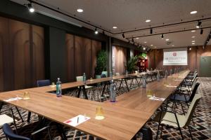 a conference room with long wooden tables and chairs at NH Collection Madrid Suecia in Madrid