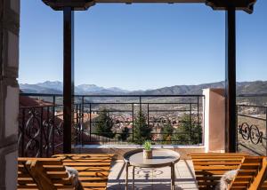 a balcony with chairs and a table and a view at Tilemachos by GM Luxury Suites Kalavryta in Kalavrita