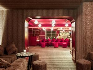 a restaurant with red chairs and tables in a room at NH Collection Madrid Suecia in Madrid