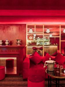 a red living room with a red couch and a table at NH Collection Madrid Suecia in Madrid