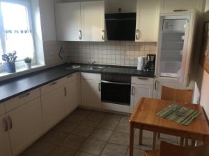a kitchen with white cabinets and a wooden table at Zinnowitz, Kneippstr 24 b in Zinnowitz +8 photos