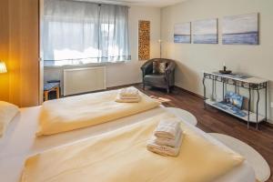 a large bedroom with two beds and a chair at Ferienhaus Mackeriege in Norden