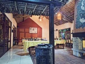 a dining room with tables and a trash can at Indri Lodge in Andasibe