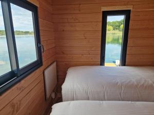 two beds in a room with windows at Bateau panoramique sans permis Lac du Der - Eclaron in Sainte-Livière