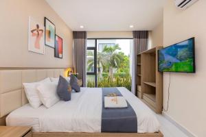 a bedroom with a large bed with a tv on the wall at ARIA Resort Vung Tau S01 in Vung Tau +38 photos