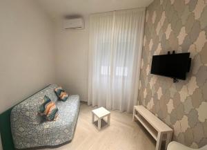 a small living room with a couch and a flat screen tv at Suite Eleven in Naples