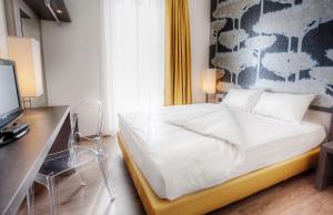 um quarto com uma cama e uma secretária com um computador em Hotel Internazionale Bellinzona em Bellinzona