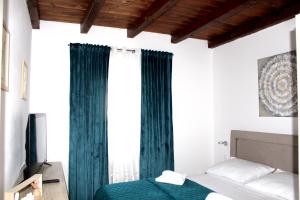 - une chambre avec des rideaux verts et un lit dans l'établissement Apartmani Lu, à Zadar