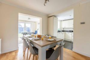 a kitchen and dining room with a table and chairs at Spacious 4-Bedroom Home - Parking - Garden in White Waltham