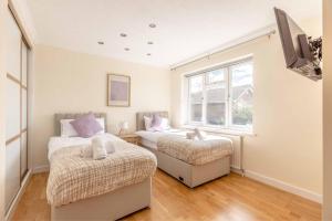 a bedroom with two beds and a window at Spacious 4-Bedroom Home - Parking - Garden in White Waltham