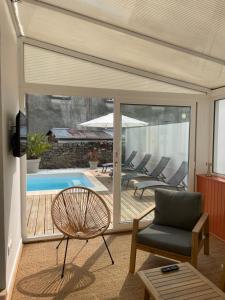 a living room with a patio with chairs and a pool at La Villa Sénéchal in Guérande