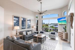 a living room with two couches and a table at Marco Island Majesty in Marco Island