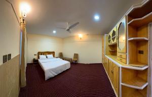 SkarduTibet Otel Skardu的卧室配有床和书架