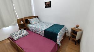 a small bedroom with a bed and a night stand at Apto Lindo, Shopping Jardim Norte, 2 Batalhão PM in Juiz de Fora +23 photos