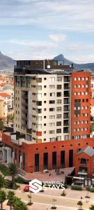 un grand immeuble d'appartements dans une ville avec un parking dans l'établissement Manhattan by Smart City Stays, au Cap