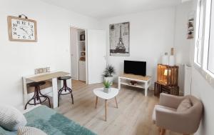 a white living room with a couch and a table at Charmant studio à 2 pas de la plage et du port in Concarneau