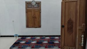a room with a door and a clock on the wall at Naufal homestay & kost in Ngemplak