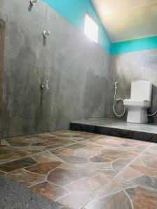 d'une salle de bains avec toilettes dans l'angle de la chambre. dans l'établissement Vitamin sea beach cabana & hostel, à Nilaveli