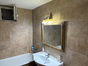 ルーマンにあるApartament S 43の洗面台、鏡、浴槽のあるバスルーム