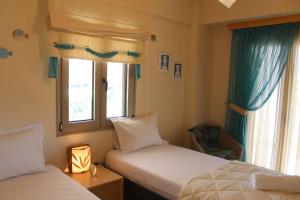 a bedroom with two beds and a window at Villa Polyxeni Magnolia 150m from the sea in Politiká +35 photos