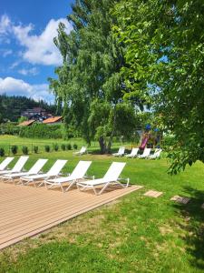 a row of white lounge chairs in a park at BERGlässig Hotel Bodenmais - 360 Grad Urlaub in Bodenmais