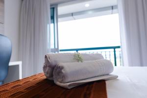 Una pila de toallas encima de una cama en V1301 Flat aconchegante próx a Esplanada, en Brasilia 22 fotos más