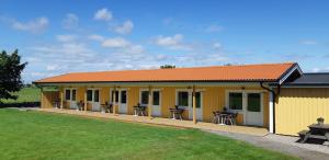 a yellow building with tables and chairs in it at Björkängs Vandrarhem in Tvååker